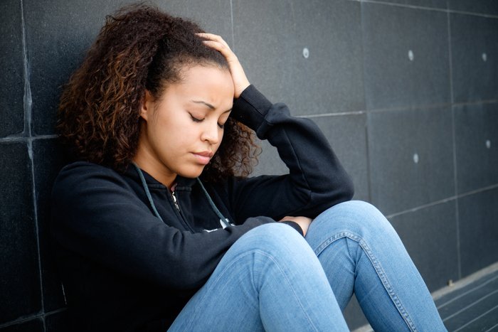 Stock image of a sitting woman feeling pain