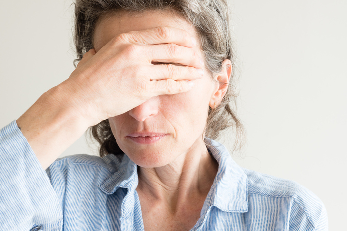Image showing a woman closing her face with her right hand