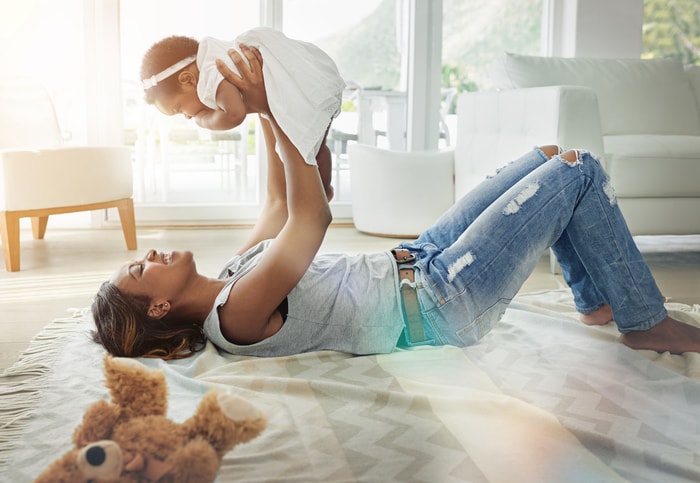 Stock image of a mother holding up her baby