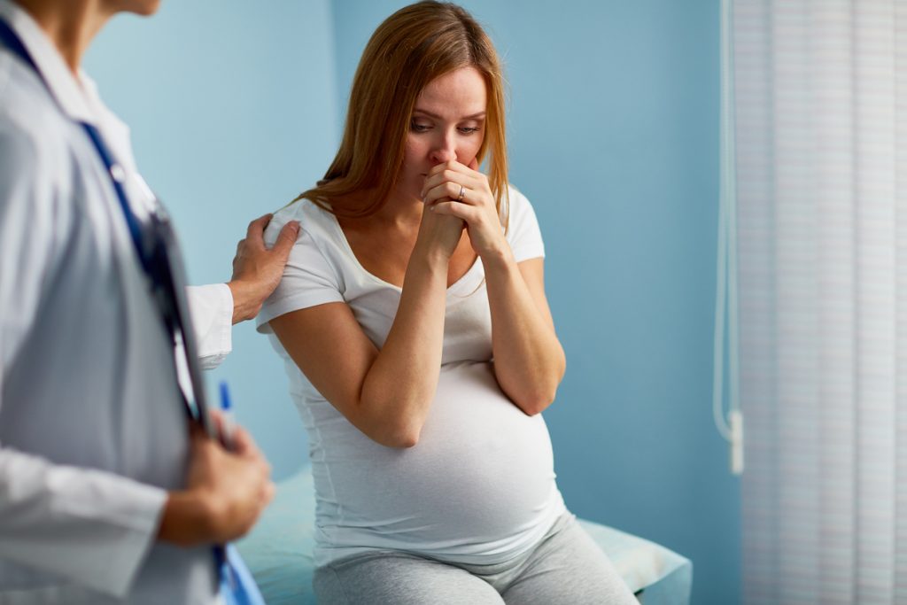 Stock image of doctor holding patient shoulder to remove her fear