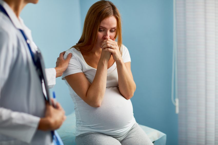 Stock image of doctor holding patient shoulder to remove her fear